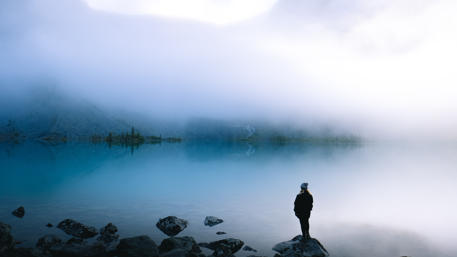 woman staring at lake in mist