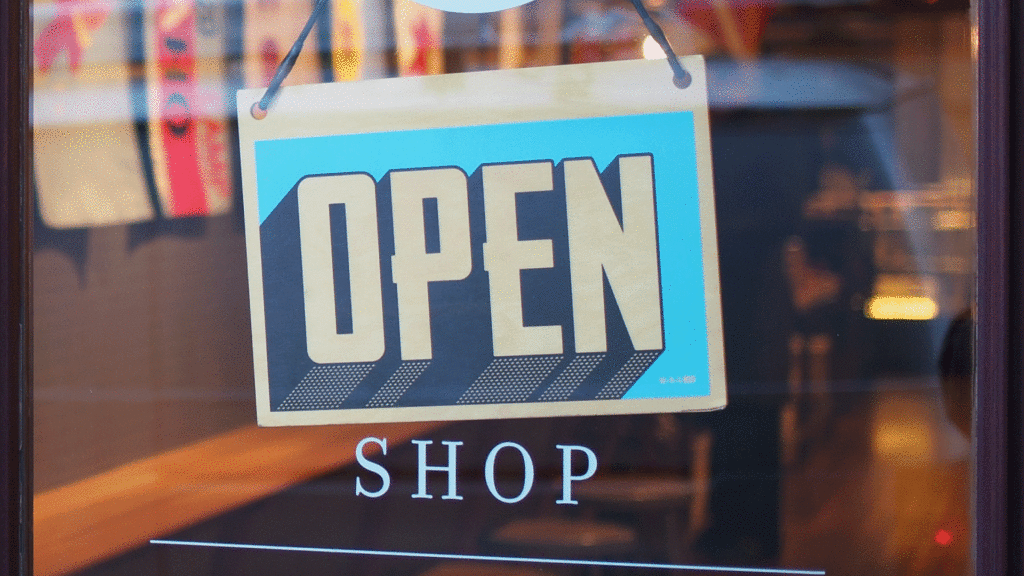 open shop sign hanging in window