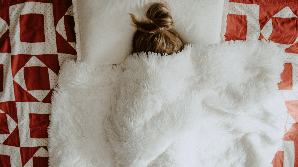 woman under furry blanket in bed